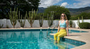 Woman Relaxing by Swimming Pool with Cactus Scenery