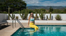 Woman Relaxing by the Pool on a Sunny Day with Cactus Garden