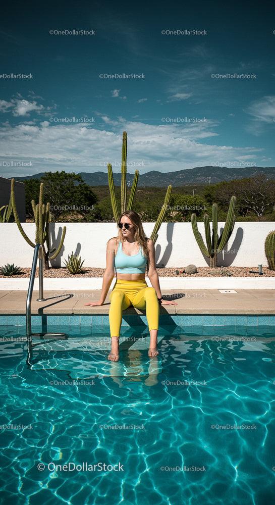 Woman Relaxing by Poolside with Cacti in the Background