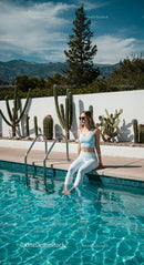 Woman Relaxing Poolside with Cacti and Mountain View