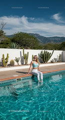 Woman Relaxing by Pool with Cactus Garden in Sunny Weather