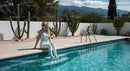 Woman Relaxing by Peaceful Poolside with Cactus Garden
