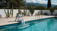 Woman Relaxing by Peaceful Poolside with Cactus Garden