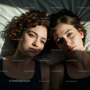 Two Women Relaxing in Gentle Sunlight on White Bedding