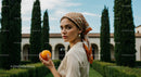 Elegant Woman with Orange in Mediterranean Garden