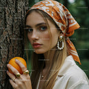 Elegant Woman with Orange and Pearl Jewelry in Nature