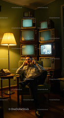 Man Relaxing in Retro Room with Vintage Televisions