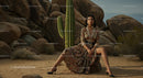 Elegant Woman in Paisley Dress Amidst Desert Rocks