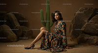 Elegant Woman in Floral Dress Sitting by Cactus in Desert