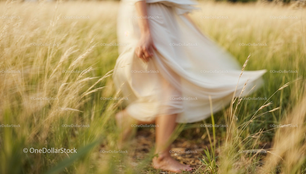 Woman in Flowing Dress Walking Through Golden Field