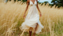 Graceful Woman in Flowing Dress in Wheat Field