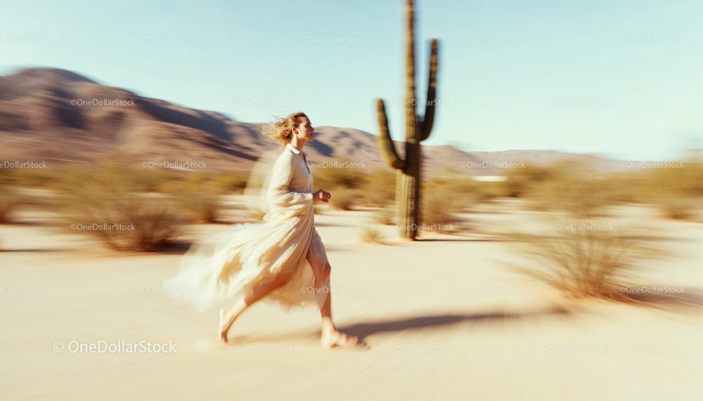 Woman in Flowing Dress Running Through the Desert