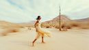 Graceful Woman in Flowing Dress Running Through Desert