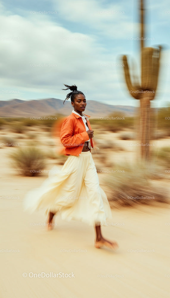 Woman in Orange Jacket Walking through Desert Landscape
