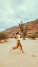 Dynamic Woman Running Through Desert with Cactus Backdrop