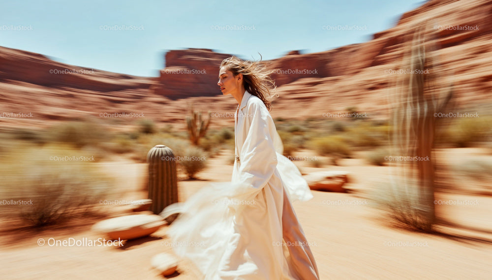 Woman in Flowing White Robe Running Through Arid Desert