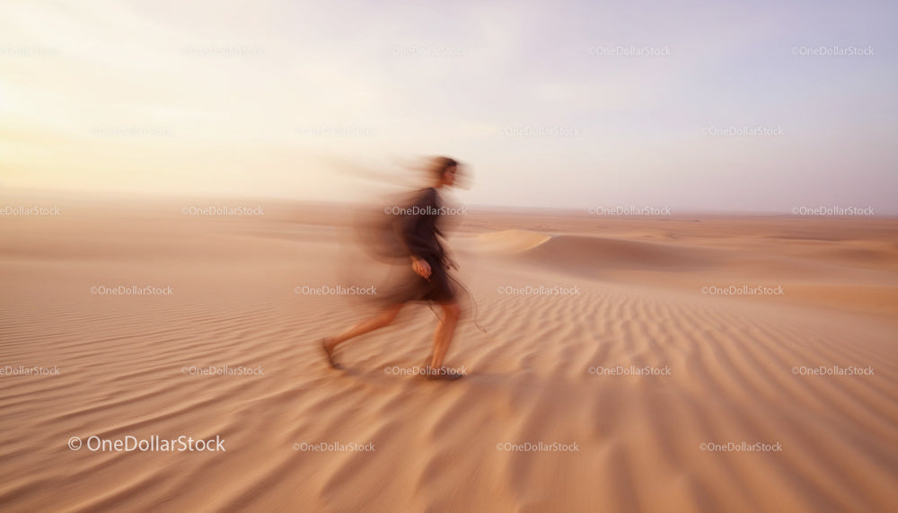 Blurred Figure Walking Across Desert During Sunset