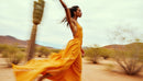 Elegant Woman in Flowing Dress Running Through Desert