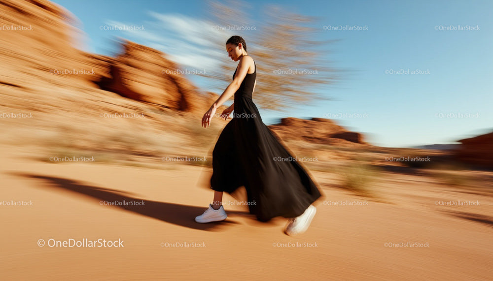 Woman in Black Dress Walking Through Desert Landscape