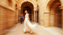 Elegant Woman in Flowing Dress Walking Through Historic Archway