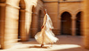 Elegant Woman in White Gown Walking Through Sunlit Arches
