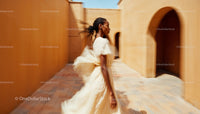 Elegant Woman in Flowing Dress Walking in Sunlit Passage