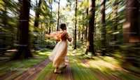 Woman in Flowing Dress Running Through Sunlit Forest