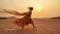 Woman Running Through Desert at Sunset in Flowing Dress