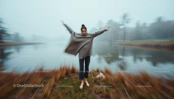 Woman in Cozy Sweater on Misty Riverbank in Autumn