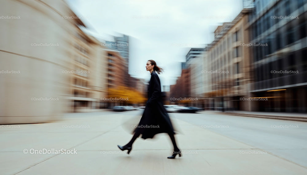 Woman in Black Coat Walking Through City with Motion Blur