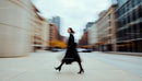 Woman in Black Coat Walking Through City with Motion Blur