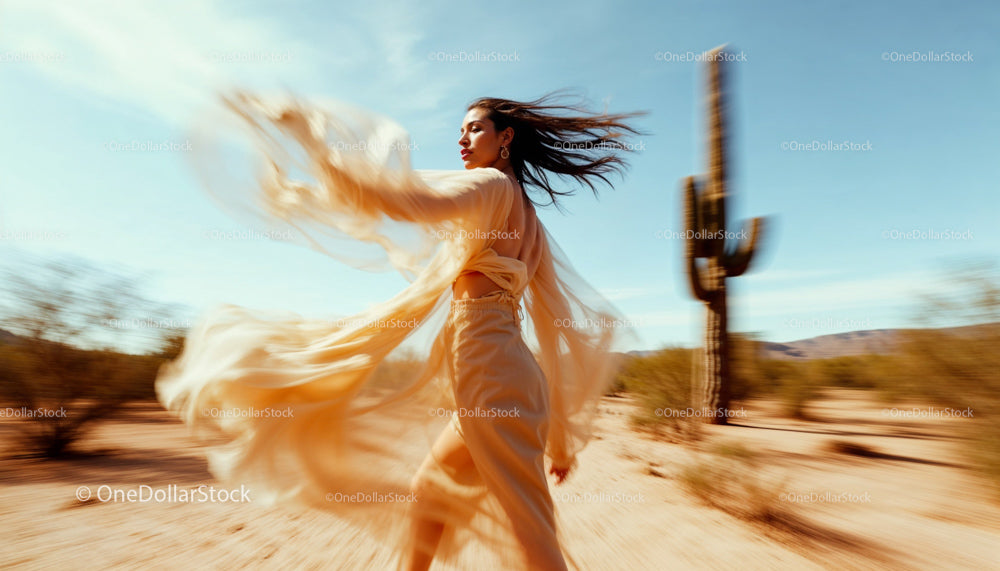 Elegant Woman in Flowing Dress Amidst Desert Landscape