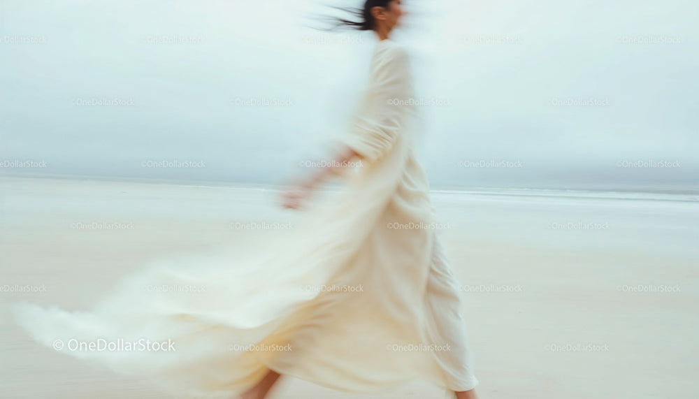 Blurred Woman in Flowing Dress on a Serene Beach