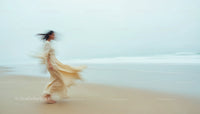 Ethereal Woman in Flowing Dress on a Tranquil Beach
