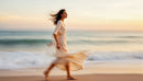 Woman in Flowing Dress Walking by the Beach at Sunset