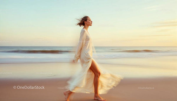 Elegancka kobieta spacerująca po spokojnej plaży o zachodzie słońca