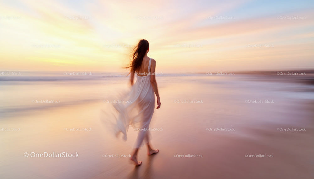Woman Strolling Along Beach at Sunset with Flowing Dress