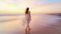 Woman Strolling Along Beach at Sunset with Flowing Dress