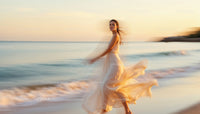 Woman in Flowing Dress Walking at Sunset Beach