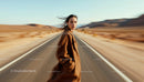 Woman in Brown Coat on Empty Desert Road
