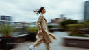 Stylish Woman in a Beige Trench Coat Walking Outdoors