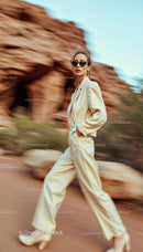 Elegant Woman in Beige Suit Walking Through Desert Landscape