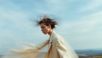 Elegant Woman in Motion Against Windy Blue Sky
