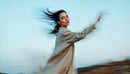 Dynamic Portrait of Woman with Windy Hair and Blue Sky