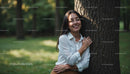 Smiling Woman Embracing Tree in Sunlit Park