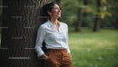 Smiling Woman in White Shirt with Brown Pants in Park