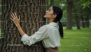 Woman Embracing a Tree in a Peaceful Forest Setting