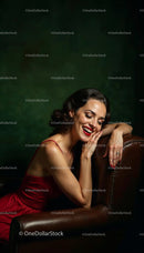 Elegant Woman in Red Dress Relaxing on Leather Chair