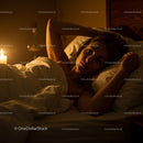 Woman Relaxing in Cozy Candlelit Bedroom