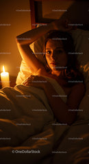 Woman Relaxing in Bed with Candlelight Ambiance
